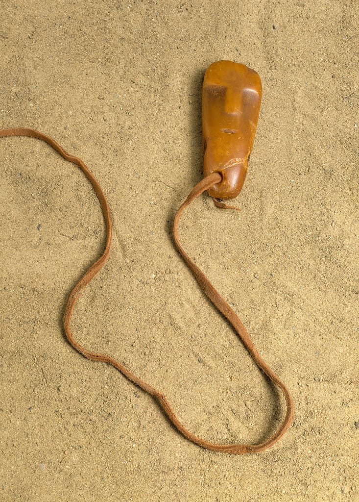 Stone age human face amber pendant